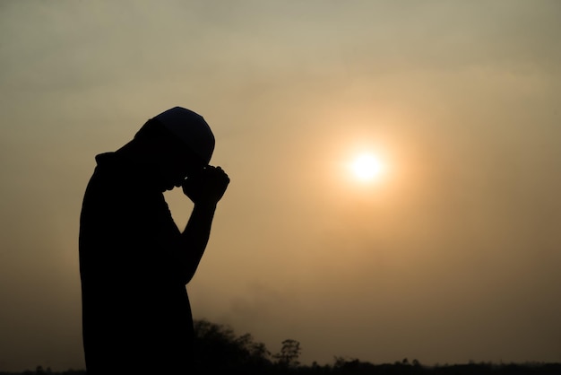 Silhouette Young asian muslim man praying on sunsetRamadan festival concept