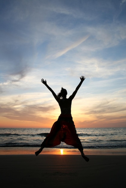 Silhouette of young beautiful woman on the beach