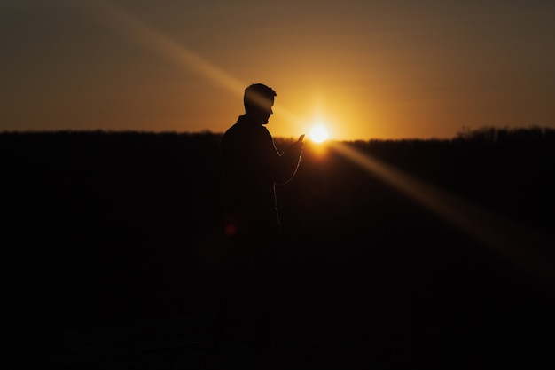 Silhouette of young man with smartphone