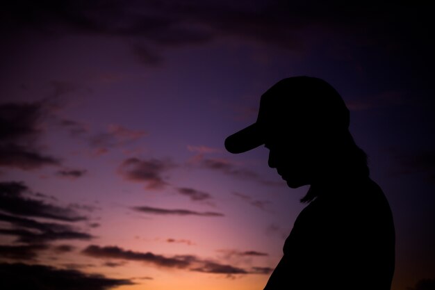 Photo silhouette of young woman standing against sunset with beautiful sky