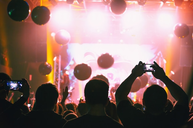 Silhouettes of a concert crowd with smartphones in their hands