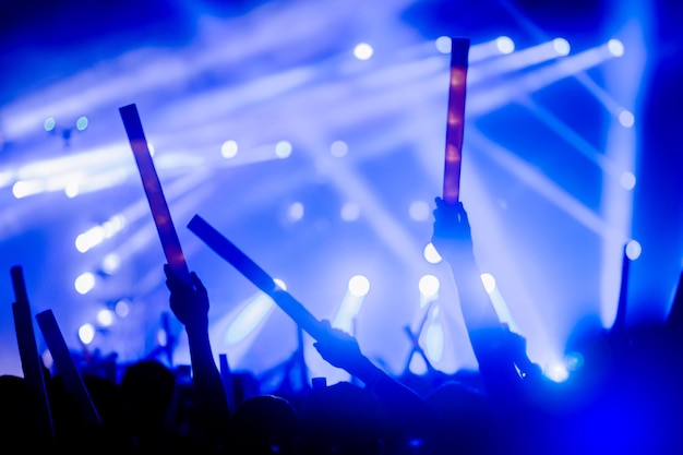 Silhouettes of hand in concert.Light from the stage.