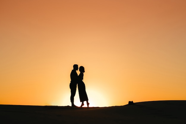 Silhouettes of a happy young couple guy and woman