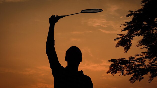 Silhouettes Man is holding the badminton racket