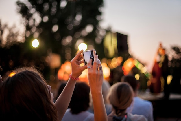 Silhouettes of people taking pictures on the phone. man taking photos of sunset with mobile phone. Silhouette of people taking pictures. A person on a bridge making a photo