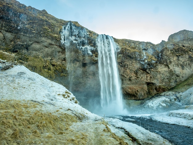 Siljalandsfoss waterfall in Iceland large waterfall with natural cliff with snow and ice around