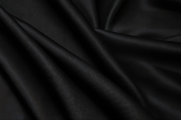 Silky black fabric on a black background