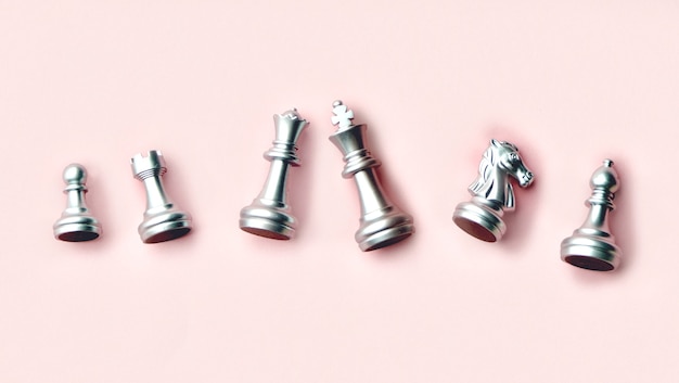 Silver chess pieces on a pink background. Chess pieces top view. Flat lay Copy space for text.