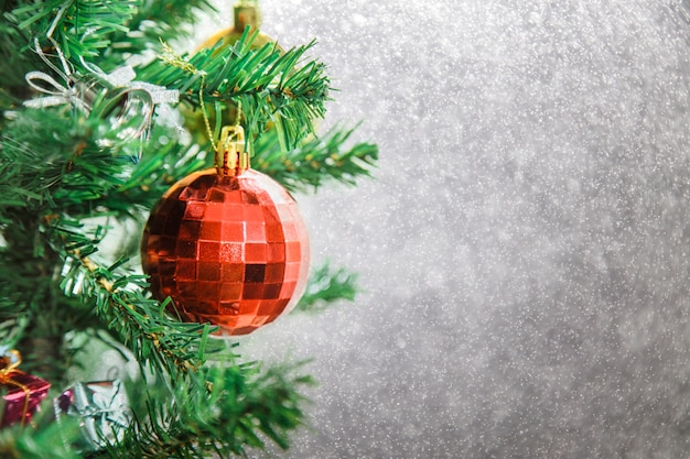 Silver Christmas background of de-focused lights with decorated tree.