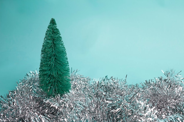 silver christmas garland and tree decoration on blue background