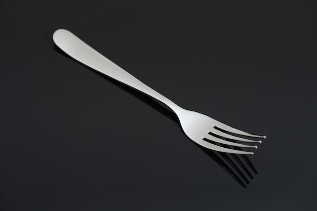 Silver fork on black background