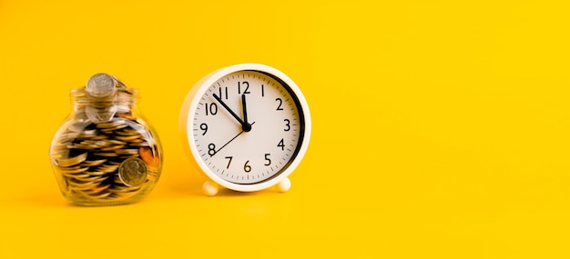 Silver in a glass bottle and a white watch on a yellow background concept of saving and time to live