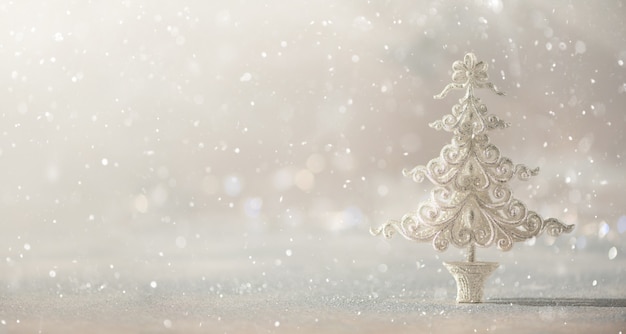 Silver glitter Christmas tree on grey background with lights bokeh, copy space. 