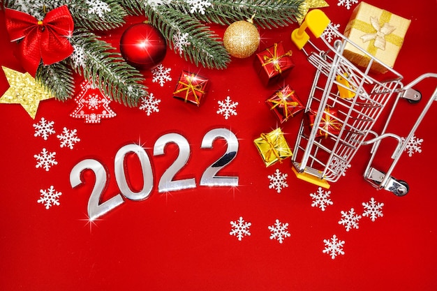 silver numbers 2022 on a red background with Christmas decorations and snowflakes