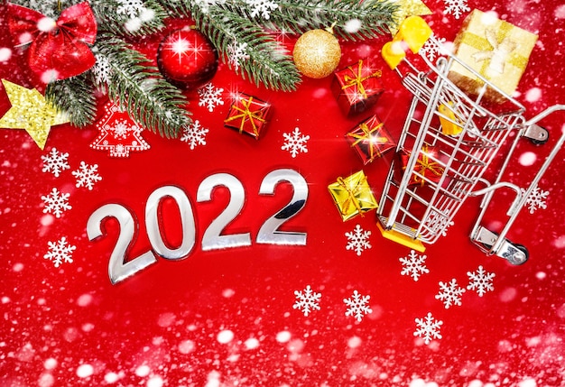 silver numbers 2022 on a red background with Christmas decorations and snowflakes