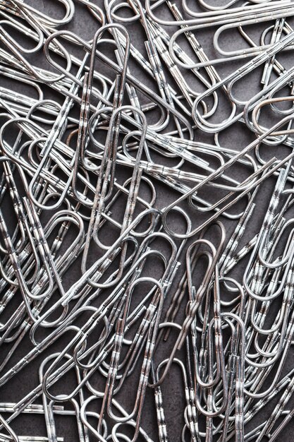 Silver paper clips textured background full screen