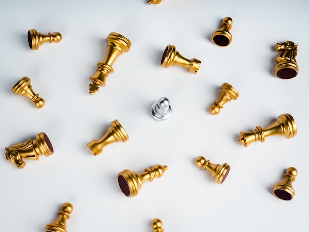 A silver pawn chess piece standing alone in the middle of many fallen silver pawn chess pieces on white background Stand out from the crowd Leadership Unique survivor winner difference concept