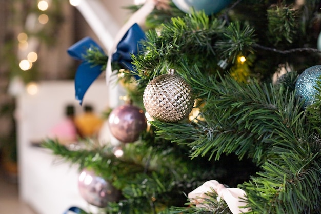 Silver and pink bauble hanging on a decorated snow tree Christmas holiday backgroundChristmas toy ball New year tree decorated with a garlandConcept Of A Happy winter holidays