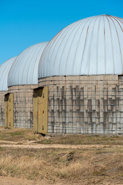 Silver silos on agro manufacturing plant for processing drying cleaning and storage of agricultural products flour cereals and grain Large iron barrels of grain Granary elevator