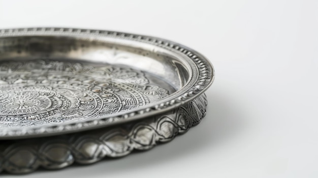 Silver tray with an embossed floral design sits on a white surface