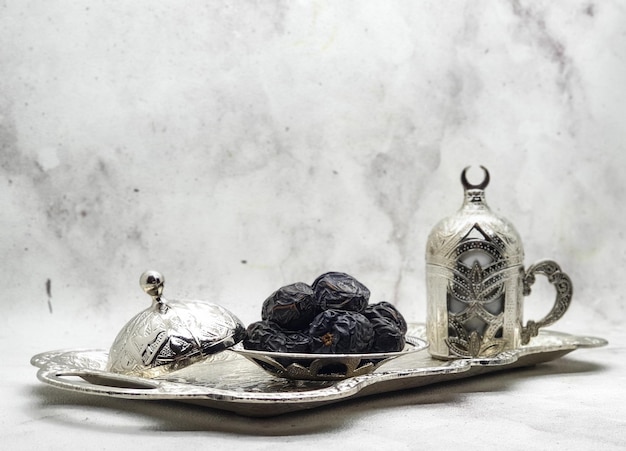 A silver tray with a jar of dates and a jar of fruit on it.