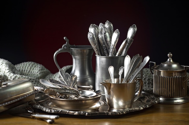 A silver tray with silverware and a green towel on it.