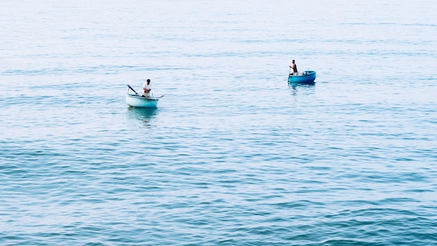 Simple background Calm dark blue sea fishing boats alone white pale Spindrift clouds Open way no limitations