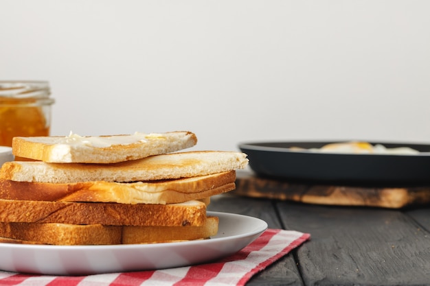 Simple breakfast. Toasted bread covered with butterclose up on wooden table