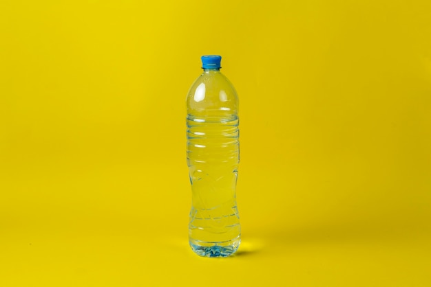 Simple plastic bottle with pure water against the colorful surface