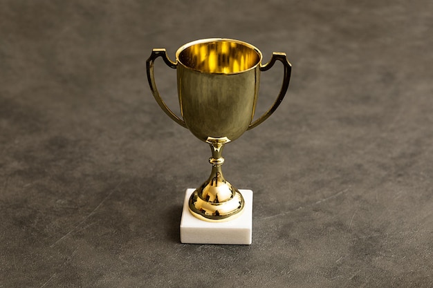 Simply design winner or champion gold trophy cup on concrete stone grey background Victory first place of competition Winning or success concept Top view copy space