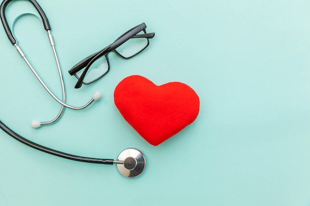 Simply minimal design medicine equipment stethoscope glasses and red heart isolated on trendy pastel blue background