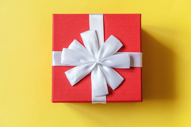 Simply minimal design red gift box isolated on yellow background