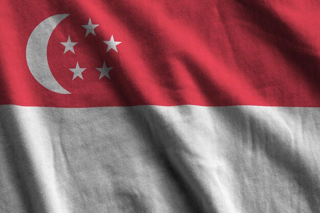 Singapore flag with big folds waving close up under the studio light indoors The official symbols and colors in banner