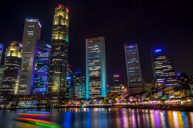 Singapore. Quay with cafes and skyscrapers. Pleasure boats. Night