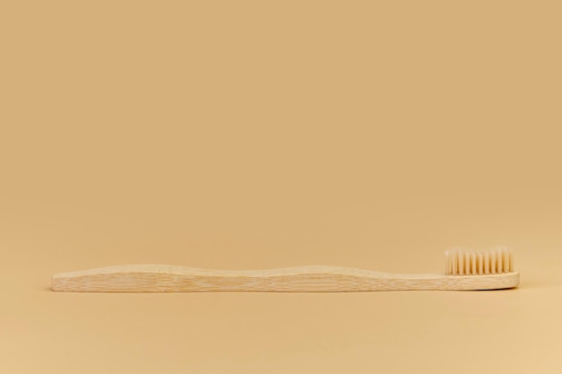 Single Bamboo wooden toothbrushe on beige background