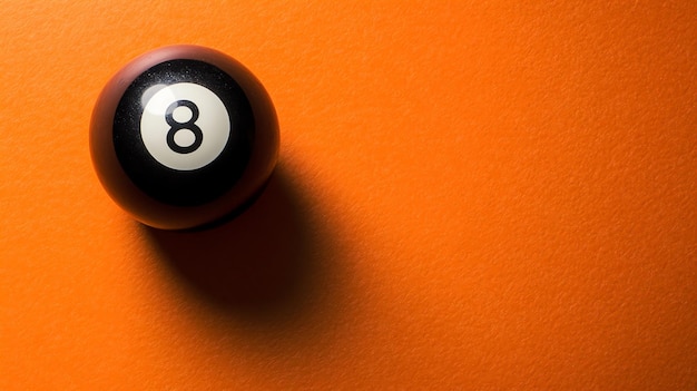 Photo a single eight ball sits on an orange surface