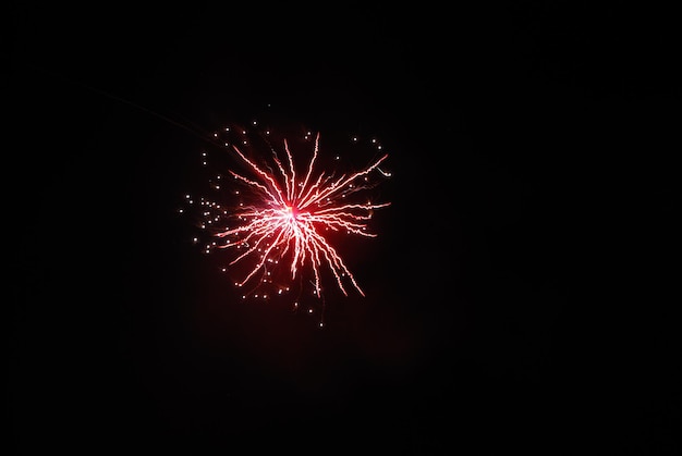 Single high bright red explosion at a fireworks display on new years eve night