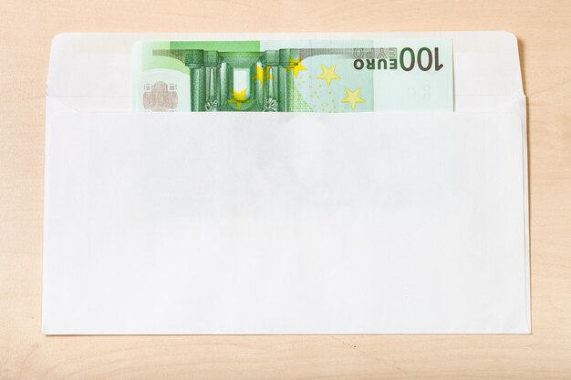 Single one hundred euro note in envelope on table