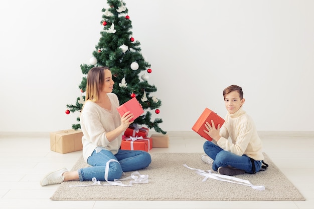 Single parent and holidays concept - Portrait of mother and child celebrating christmas at home on christmas eve