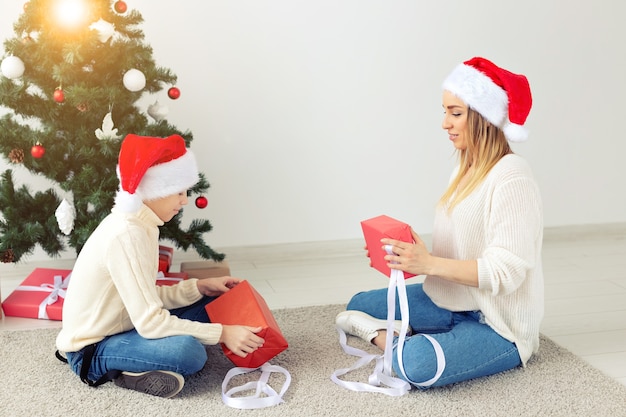 Single parent and holidays concept - Portrait of mother and son celebrating christmas at home on christmas eve