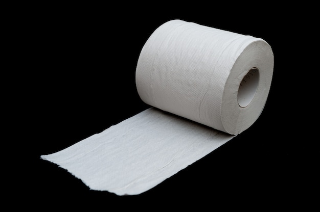 Single roll of unrolled white toilet paper isolated on black background