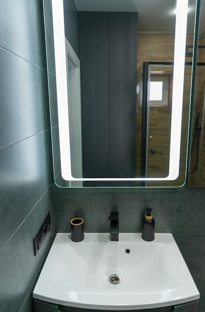 Single white hand basin, vanity and mirror in a bathroom