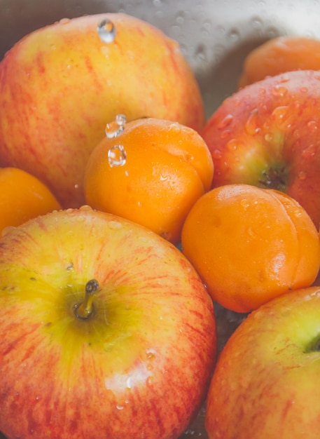 In the sink peaches and apples from the falling drops.