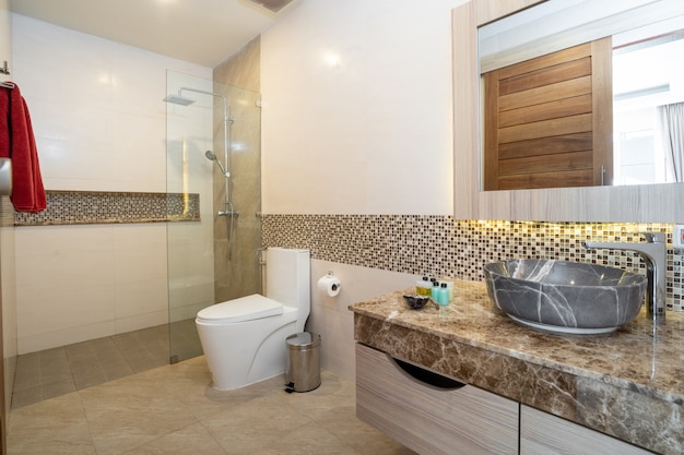 Sink with top granite, toilet and shower in a house