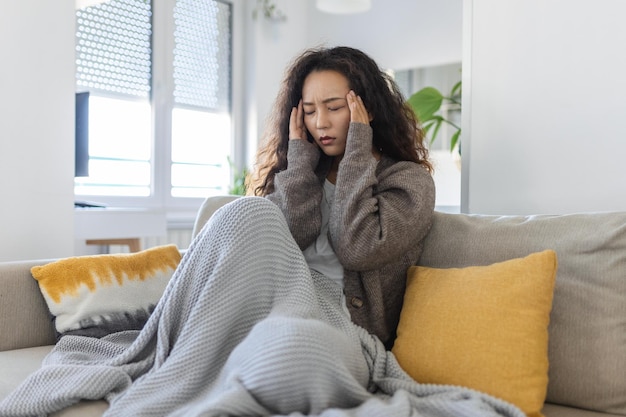 Sinus ache causing very paintful headache Unhealthy Asian woman in pain Sharp strong sore Sinus pain sinus pressure sinusitis Sad woman holding her head because sinus pain