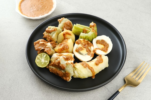 Siomay Bandung Shumay or steamed dumplings with boiled egg tofu potatoes and cabbage roll