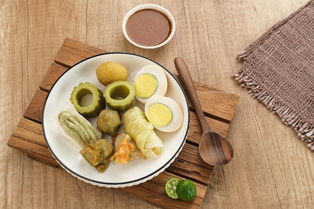 Siomay Bandung (Shumay) or steamed dumplings with boiled egg, tofu, potatoes and cabbage roll.