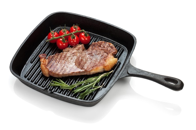 Sirloin steak with rosemary and cherry tomatoes cooking in a frying pan