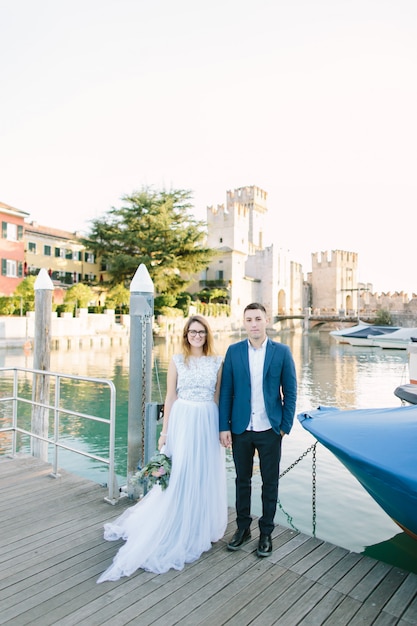 Sirmione, Lago di Garda, Italy. Charming couple in love hugging and kissing on the bridge in Sirmione