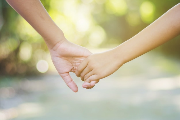 sister and brother hand in hand walking together in forest